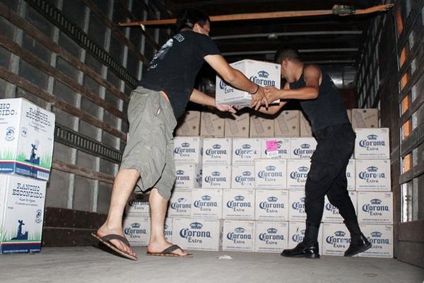 Agentes de la Policía descargan la mercadería que fue ingresada al país de contrabando. (Foto Prensa Libre: Rolando Miranda)<br _mce_bogus="1"/>