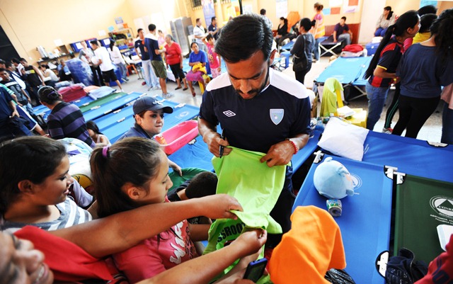 El delantero y capitán de la Bicolor Carlos Ruiz firma una playera en el Albergue Municipal de Santa Catarina Pinula (Foto Prensa Libre: Francisco Sánchez)