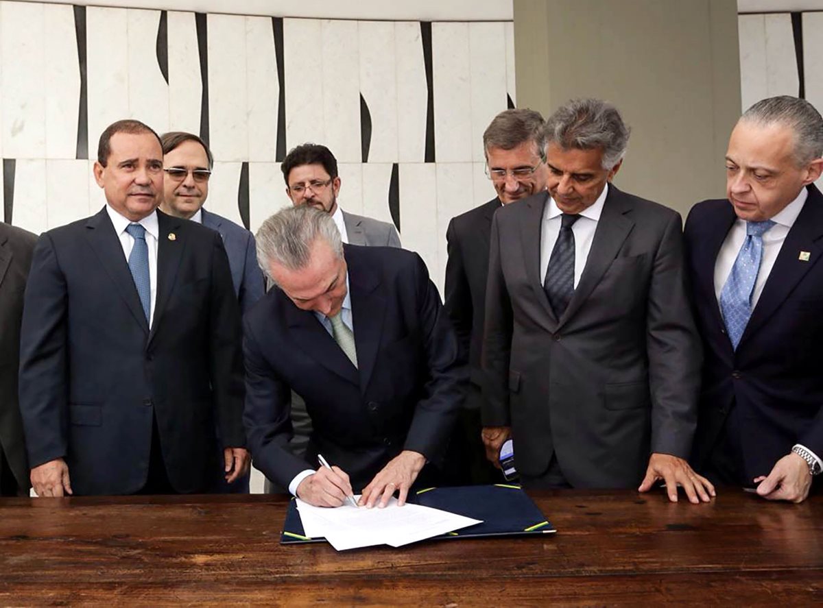 El presidente interino de Brasil, Michel Temer, al momento que le es llevada la notificación de la suspensión de Dilma Rousseff. (Foto Prensa Libre: EFE).