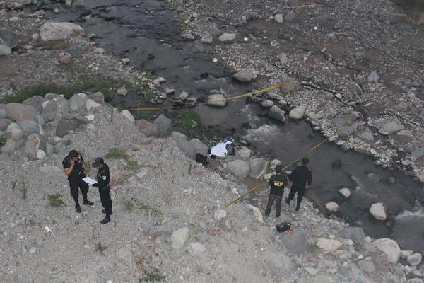 Agentes de la PNC acordonan el lugar donde apareció el cadáver. (Foto Prensa Libre: Angel Julajuj)<br _mce_bogus="1"/>
