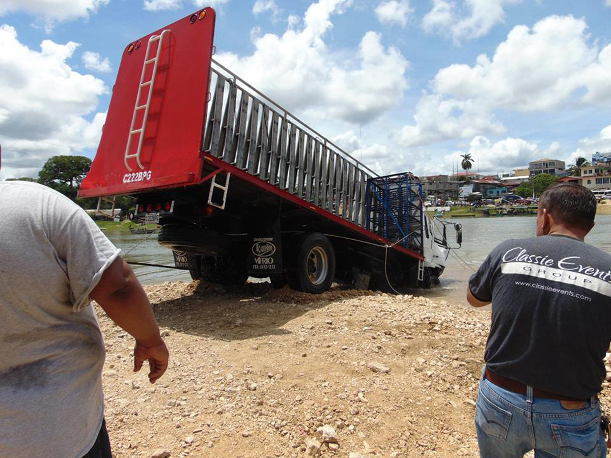 Vecinos ayudan a sacar el camión que cayó en el río La Pasión. (Foto Prensa Libre: Dony Stewart).