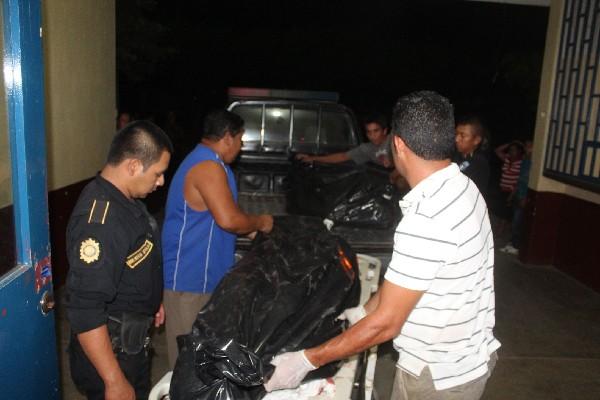 Las autoridades trasladan los cuerpos de  Elvis Rodolfo García y su tío Daniel Jiménez, quienes  murieron baleados.