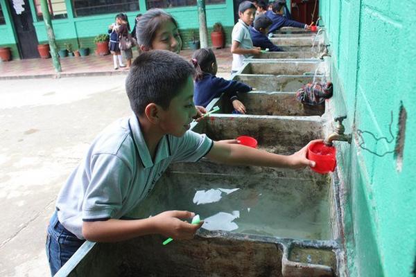 Niños de la Escuela Oficial Urbana 15 de Septiembre se benefician con agua clorada. (Foto Prensa Libre: José Rosales)