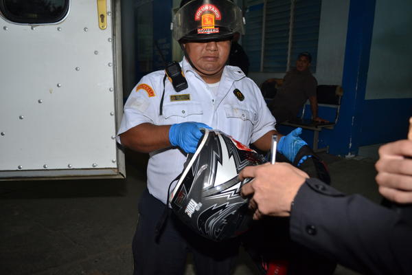 Un socorrista de Bomberos Voluntarios entrega el caso de la víctima, a un familiar en el centro asistencial. (Foto Prensa Libre: Víctor Gómez)<br _mce_bogus="1"/>
