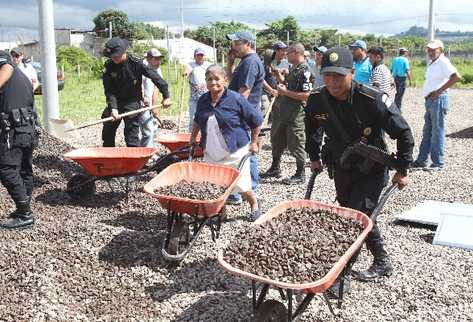 Mujeres  de la tercera edad, vecinos, agentes de la Policía  y soldados  trasladan materiales para habilitar los módulos en donde funcionará el escuadrón de seguridad de Villa Nueva.