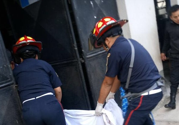 Bomberos trasladan uno de los cadáveres. (Foto Prensa Libre: Eduardo Sam).