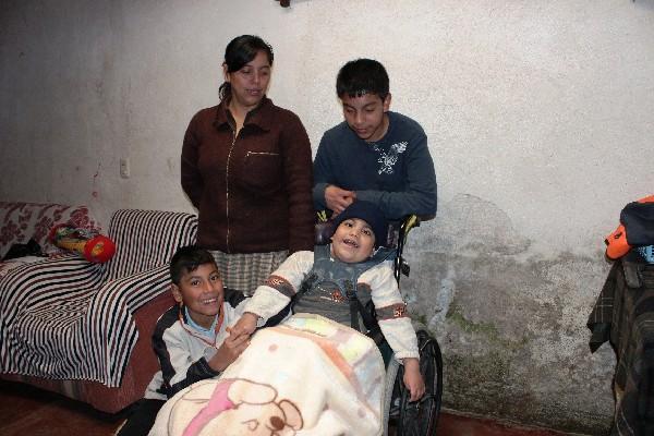 Joshua Yac Ramos, en la silla de ruedas,  acompañado de su familia, en Cantel.