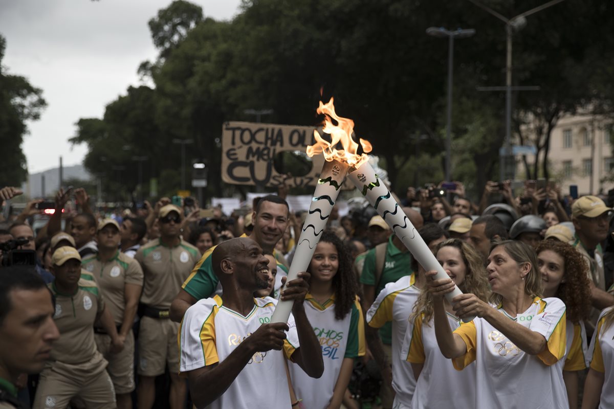 Varios artistas brasileños participaron de relevos de la llama olímpica. Renato Sorriso hace el relevo con Carla Camurati. (Foto Prensa Libre: AFP)