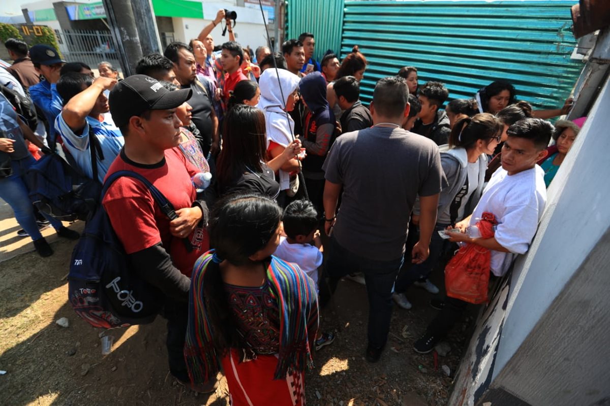 Los guatemaltecos deportados salen por el espacio de una obra en construcción. (Foto Prensa Libre: Carlos Hernández)