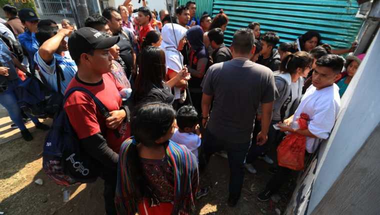 Los guatemaltecos deportados salen por el espacio de una obra en construcción. (Foto Prensa Libre: Carlos Hernández)