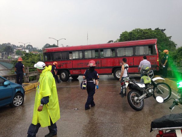 El autobús quedó atravesado en el puente. En el derrape golpeó a un automóvil. (Foto Prensa Libre: Bomberos Municipales)