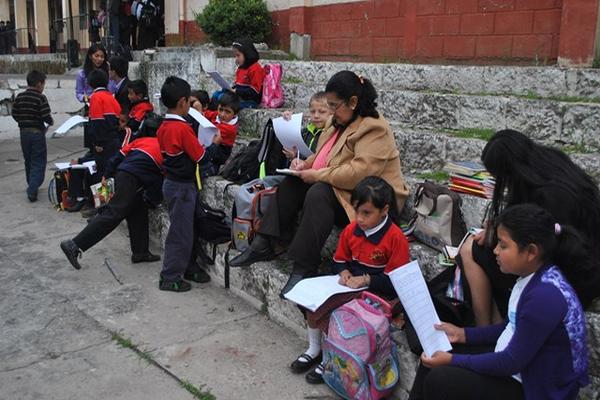 Maestra de la Escuela Naciones Unidas, de la cabecera de San Marcos,  atiende a sus estudiantes en la acera. (Foto Prensa Libre: Aroldo  Marroquín)