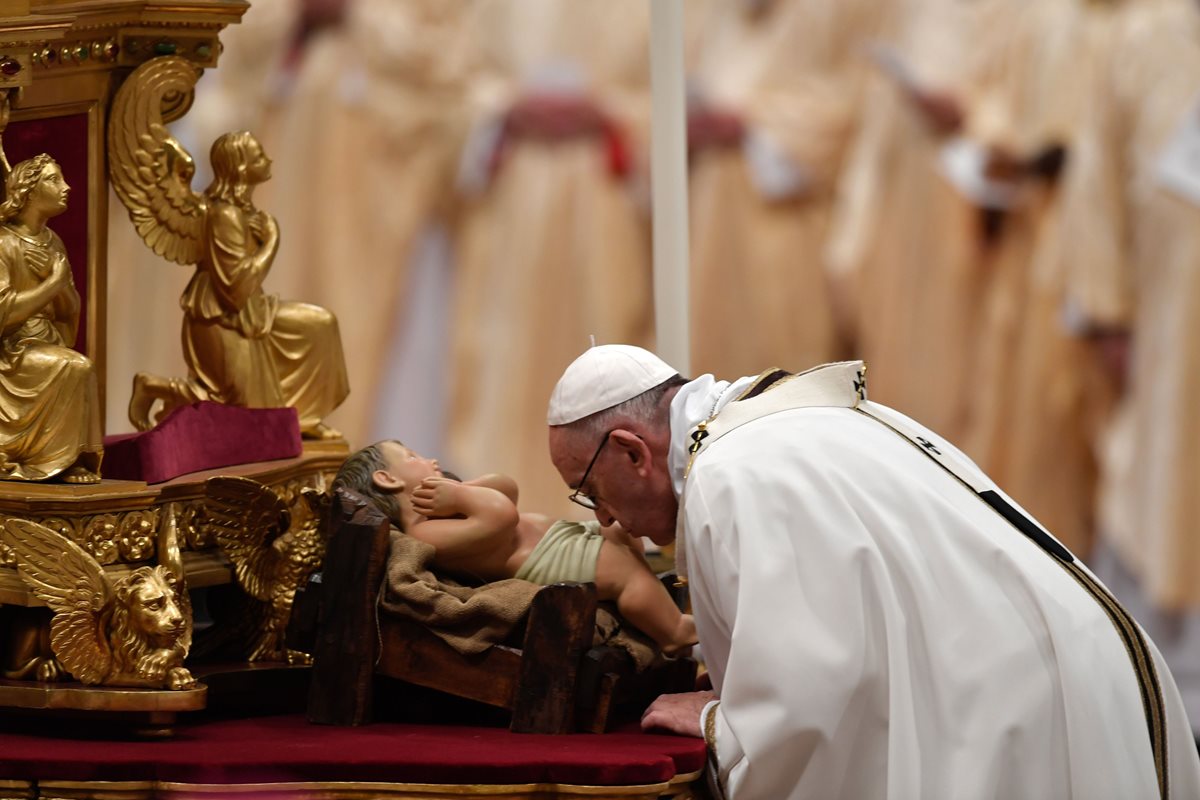 El papa Francisco besa una imagen de bebé Jesús durante una misa en Nochebuena en el Vaticano. (Foto Prensa Libre:AFP).