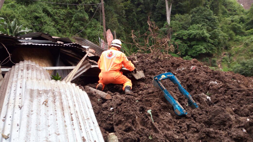 Un bombero trabaja en el lugar del derrumbe. (Foto Prensa Libre: Bomberos Voluntarios).