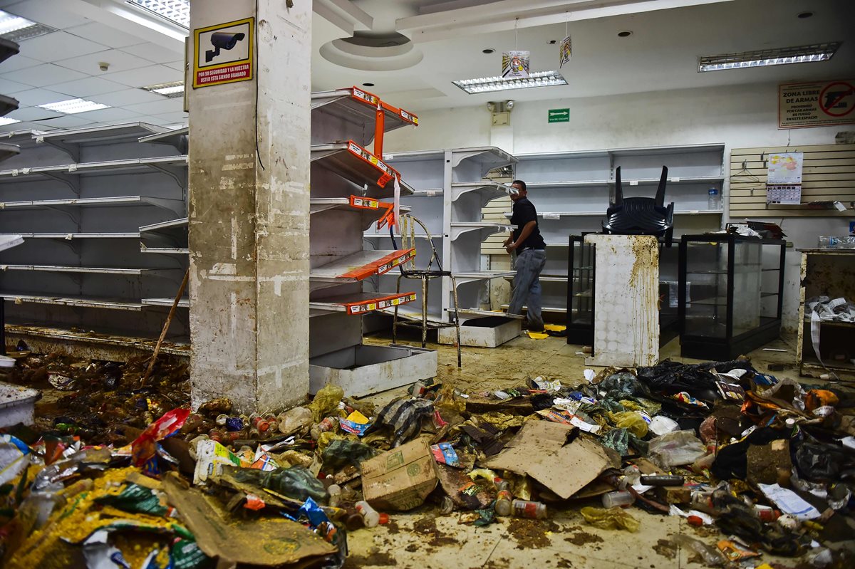Varios comercios son saqueados en Venezuela, aprovechando el caos de manifestaciones. (Foto Prensa Libre: AFP)