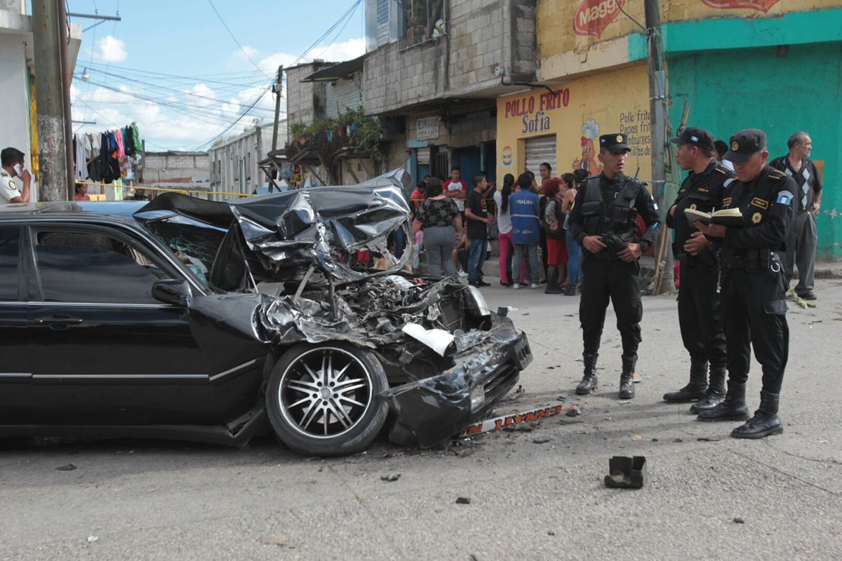Agentes de la PNC inspeccionan el automóvil que fue baleado y luego colisionó contra un autobús. (Foto Prensa Libre: Erick Ávila)