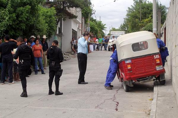 Fiscales del Ministerio Público recaban evidencias en el lugar donde murió el piloto del mototaxi. (Foto Prensa Libre: Hugo Oliva).