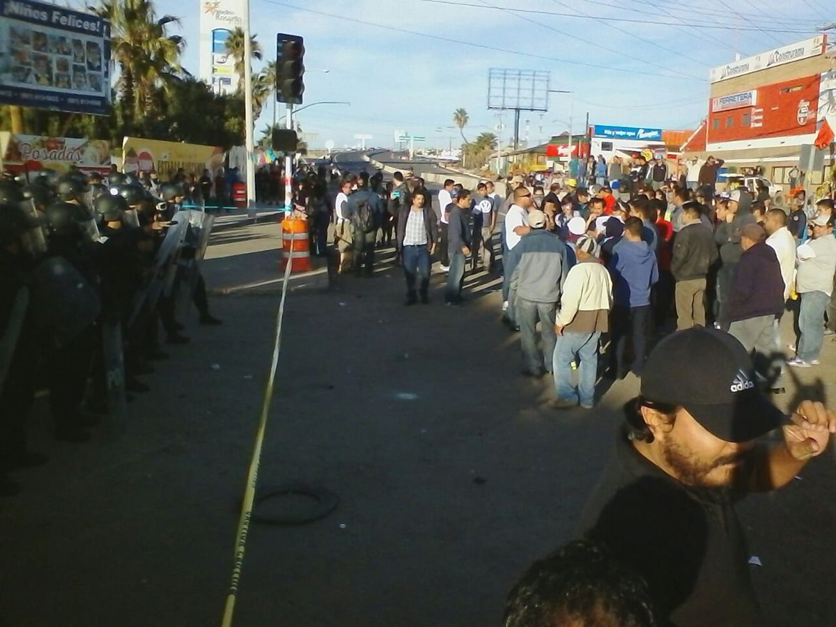 Un grupo de manifestantes durante la protesta en el ingreso a la planta petrolera Pemex de Tijuana. (Foto Prensa Libre: EFE)