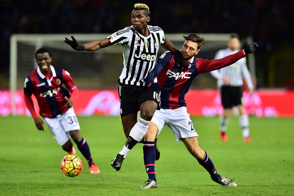El fránces Paul Pogba, al centro, intenta dominar el balón ante jugadores de la Bologna. (Foto Prensa Libre: AFP)