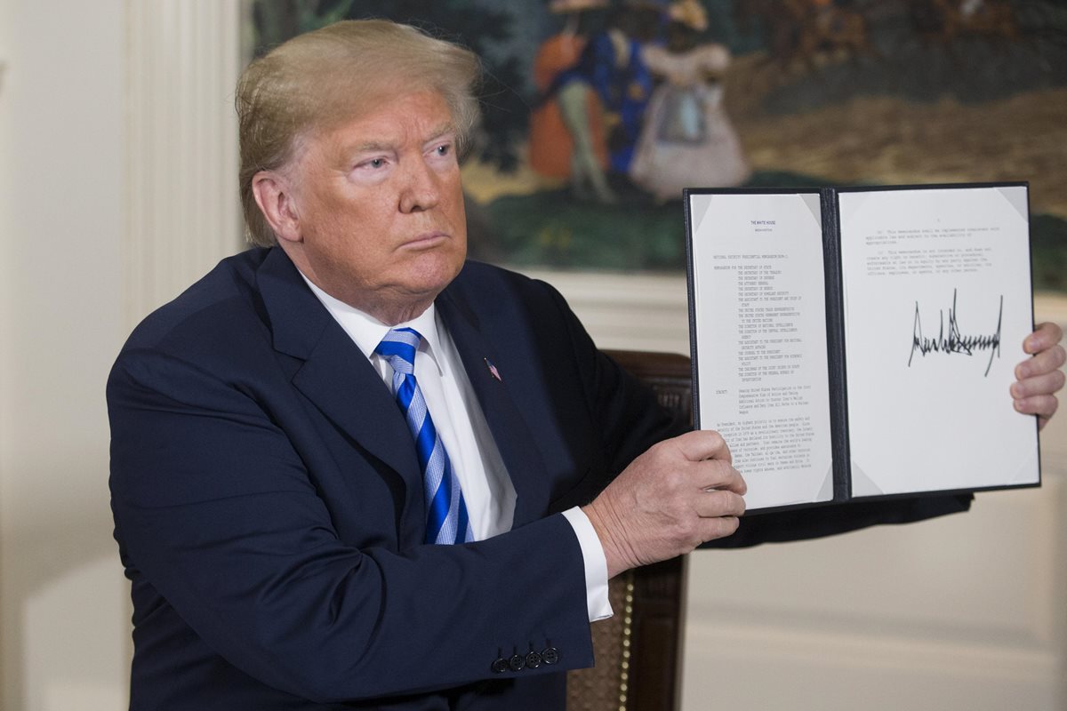 Donald Trump sostiene un memorándum presidencial de seguridad nacional sobre la cancelación del pacto nuclear con Irán que firmó en la Casa Blanca. (Foto Prensa Libre:AFP).