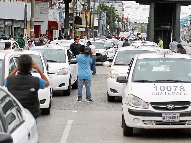 Un grupo de taxistas aprovechó la marcha por el 20 de octubre y rechazó ayer la llegada de Uber. 
FOTO: Álvaro Interiano.