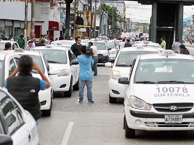 Un grupo de taxistas aprovechó la marcha por el 20 de octubre y rechazó ayer la llegada de Uber. 
FOTO: Álvaro Interiano.
