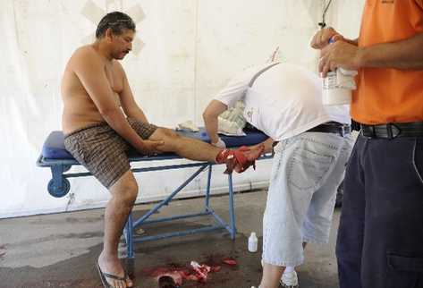 Paramédicos auxilian a un hombre que fue mordido por pirañas en Rosario, Argentina. (Foto Prensa Libre: AP)