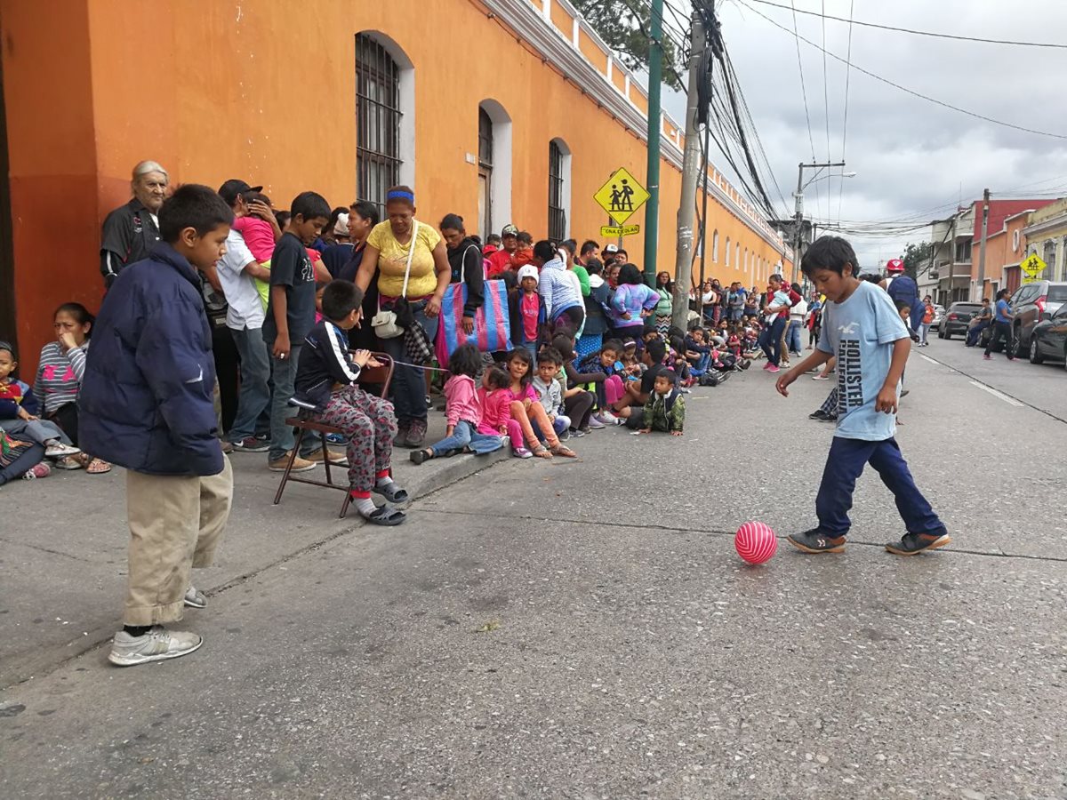 Niños con sus padres de familia esperan sus regalos en las afueras de la Rectoría de Belén, zona de la capital. (Foto Prensa Libre: Óscar Rivas).