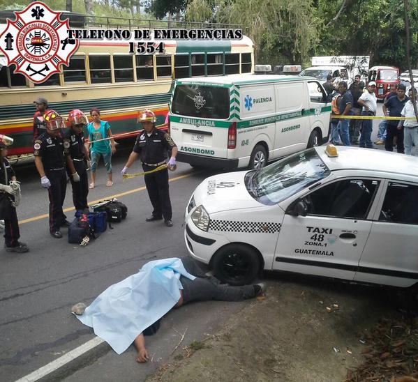 El cuerpo de la víctima yace al lado del taxi que conducía. (Foto Prensa Libre: Bomberos Municipales Departamentales)