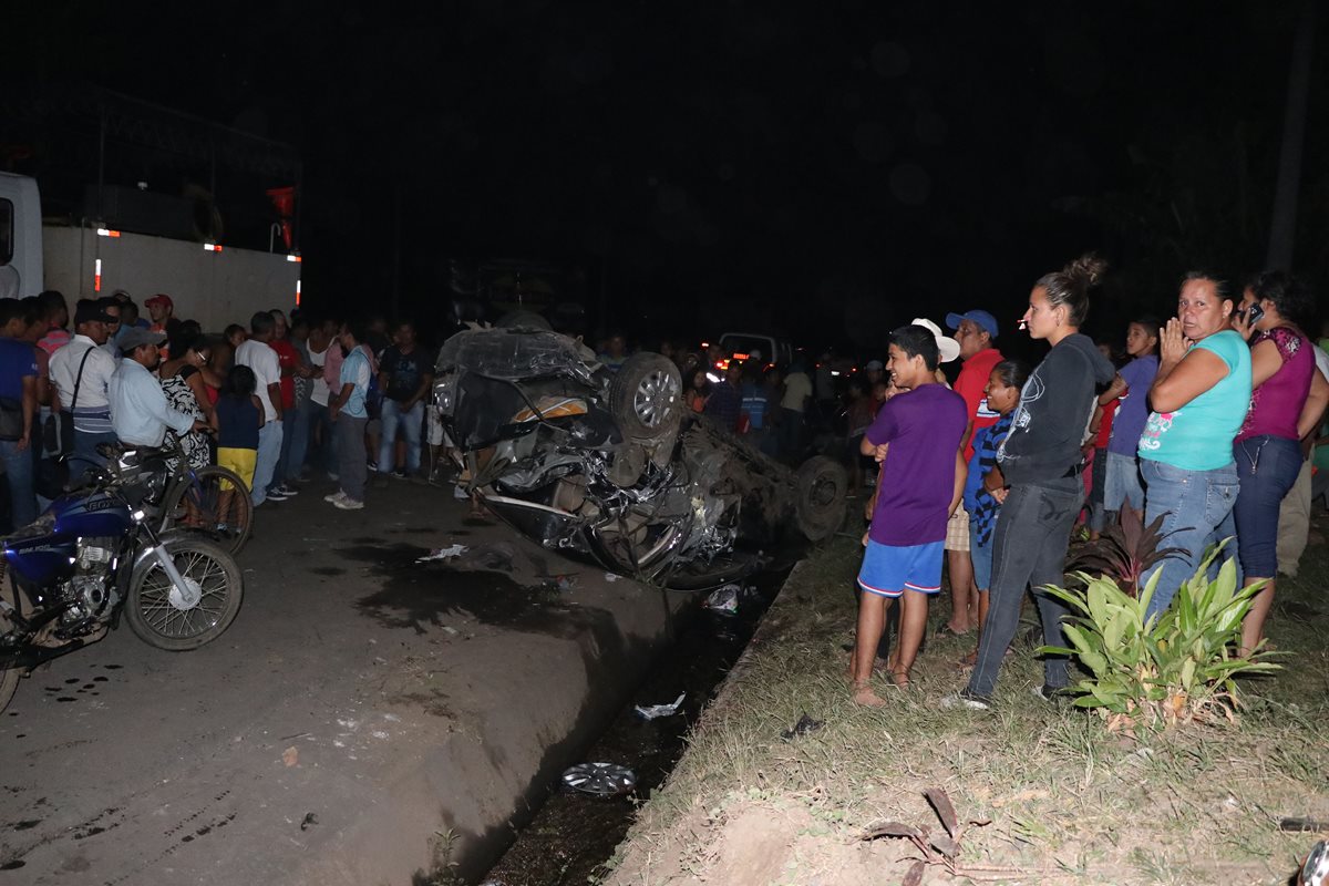 Curiosos observan cómo quedó uno de los vehículos que fueron arrollados por el tráiler sin frenos. (Foto Prensa Libre: Enrique Paredes).