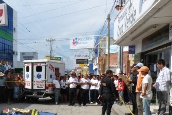 Curiosos observan el cadáver de Andrea Alejandra Mateo López, quien murió atropellada, en Sanarate. (Foto Prensa Libre: Héctor Contreras)