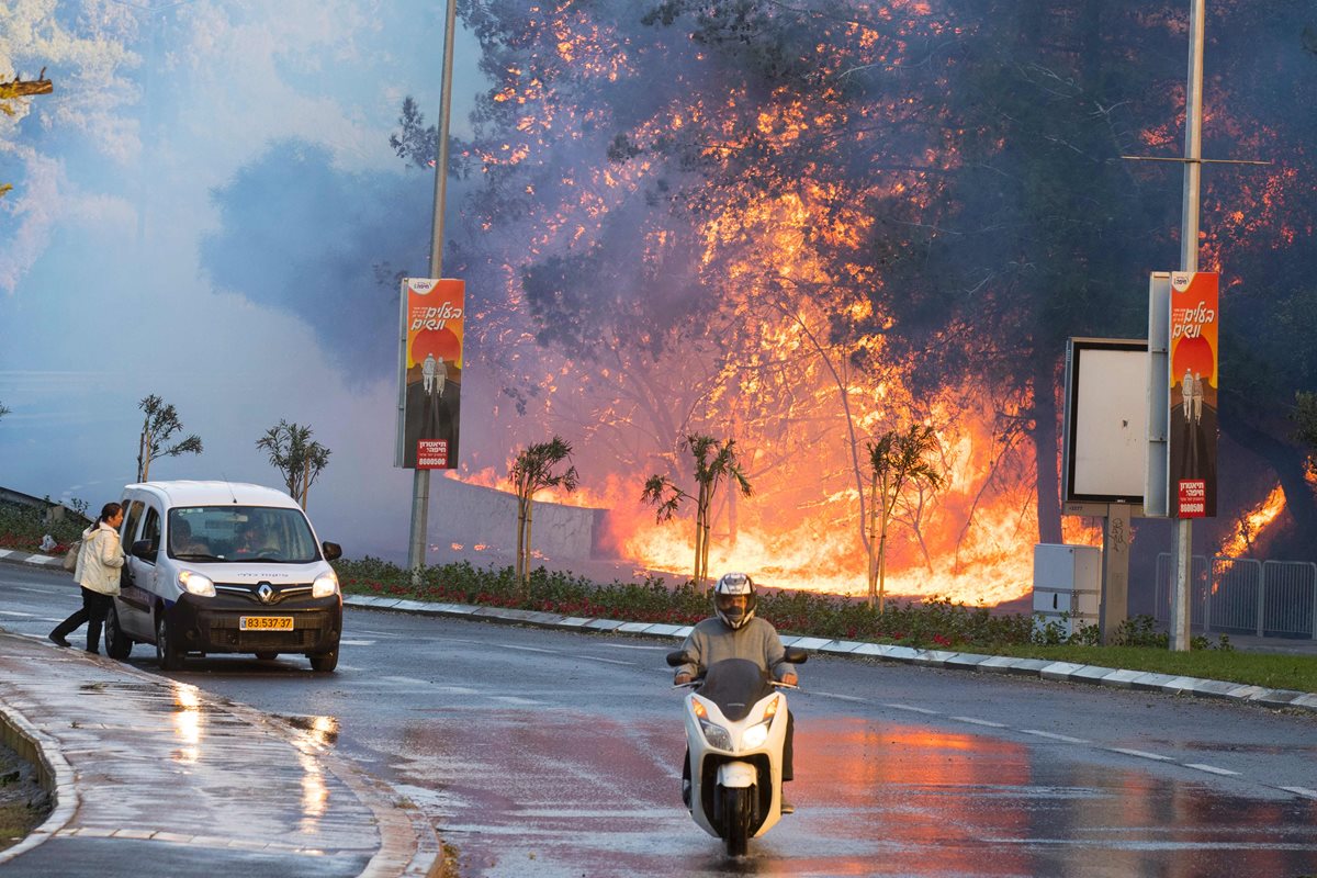 Habitantes de Haifa huyen del fuego amenazante. (Foto Prensa Libre: AFP).