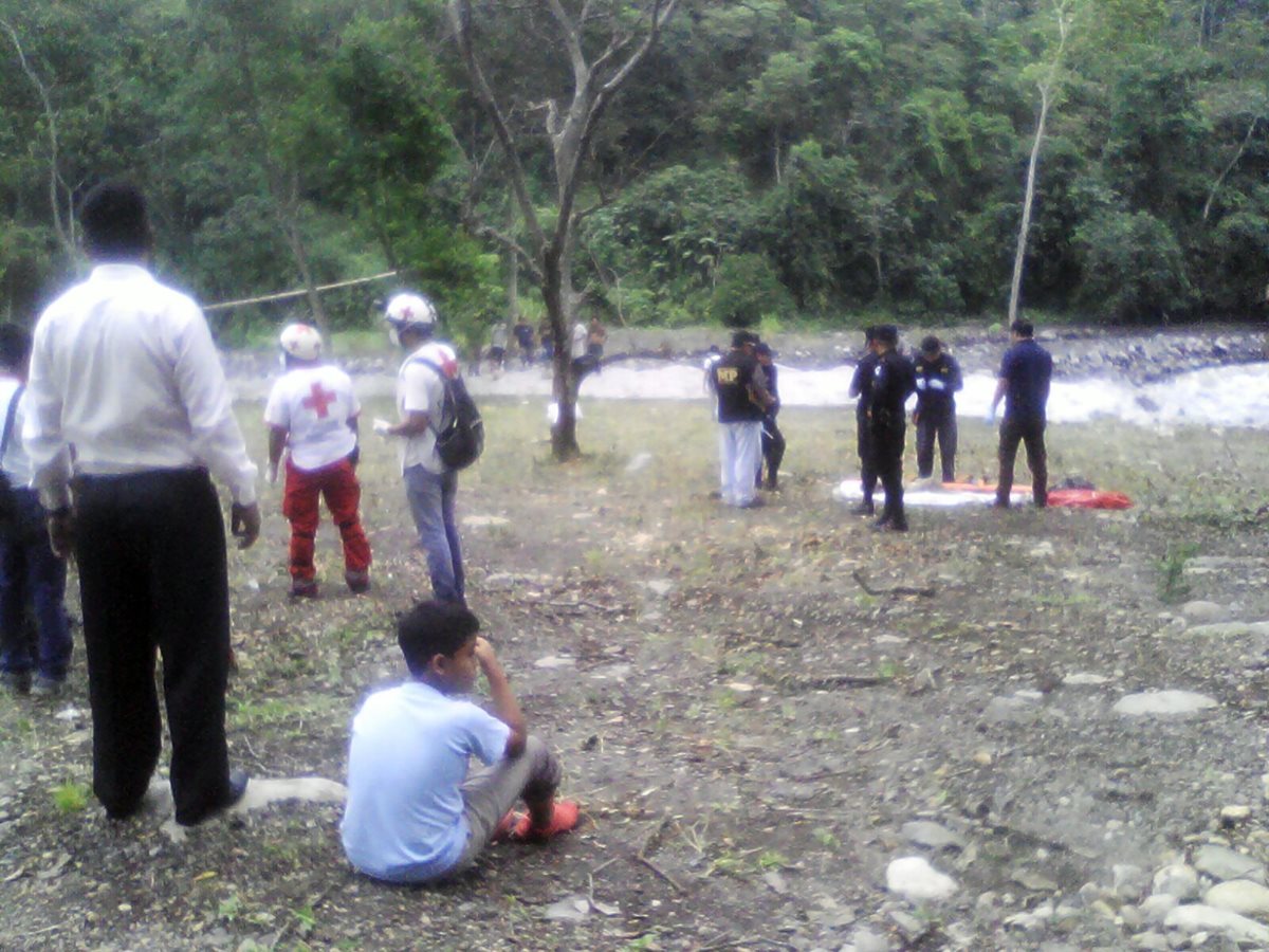 Vecinos del barrio La Llovizna, en San Felipe, Retalhuleu, observan cuando agentes de la PNC recogen evidencias. (Foto Prensa Libre: Jorge Tizol)