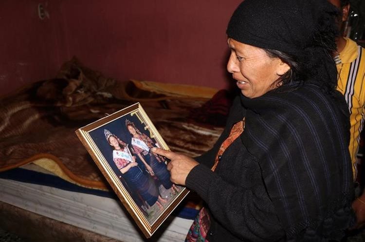 La madre de Lisbet Méndez observa una de sus fotografía de cuando fue Madrina de los Papicultores de Concepción Chiquirichapa, Quetzaltenango. (Foto Prensa Libre: Carlos Ventura)