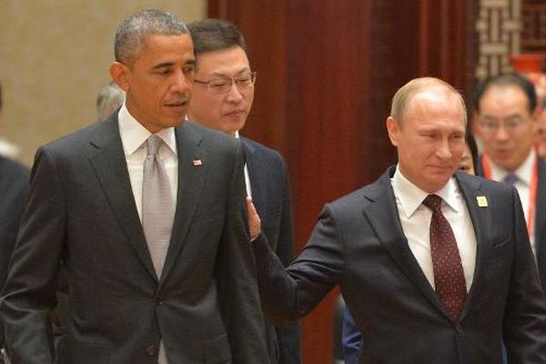 Vladimir Putin toca en el brazo a Barack Obama a su llegada a la sesión  plenaria de la cumbre de la APEC, en Pekín. (Foto Prensa Libre: AFP)