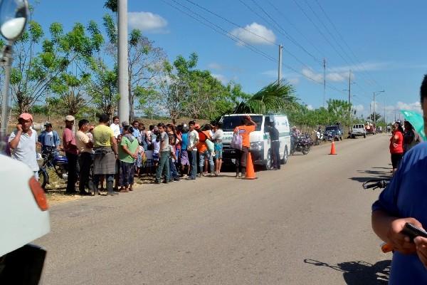 Curiosos observan el cadáver de César Miguel, ultimado en el caserío El Tamarindo.