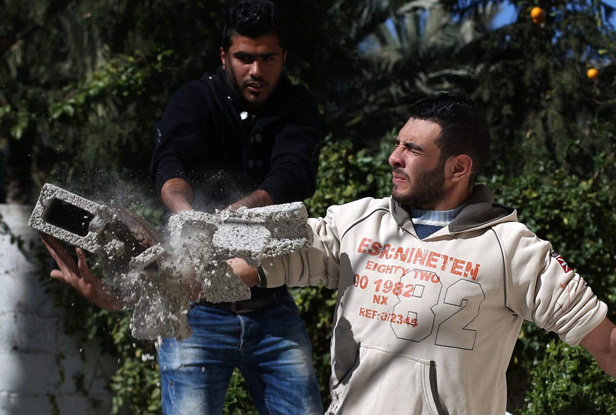 Mohamed Baraka, el hércules de Gaza, rompe un block para mostrar su fuerza. (Foto Prensa Libre: AFP).