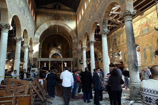 Fuerzas de seguridad egipcia incestgan la escena del atentado en la catedral. (Foto Prensa Libre: AFP)