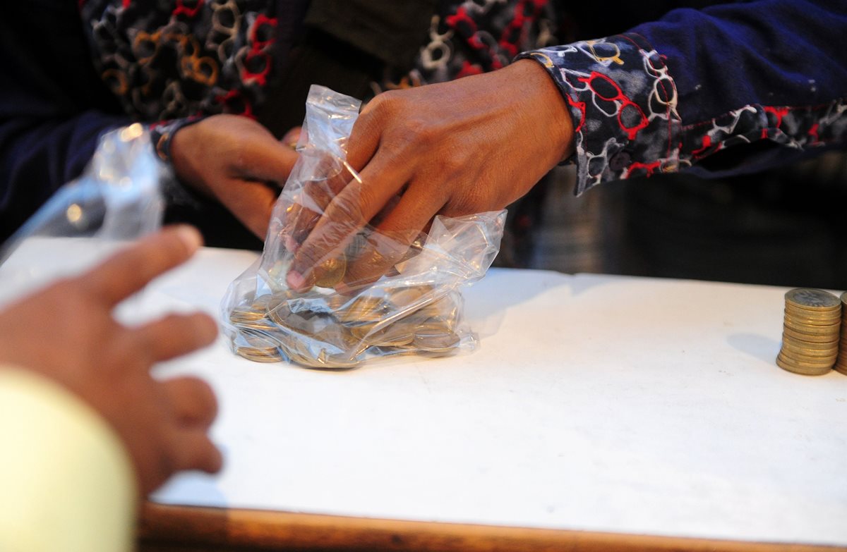 Una mujer intercambia monedas en Allahabad, India.(Foto Prensa Libre: AFP).
