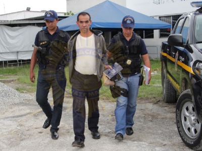 Agentes de policía trasladan a Rafael Santano Asencio y Asencio tras arribar al aeropuerto La Aurora. (Foto Prensa Libre: PNC)