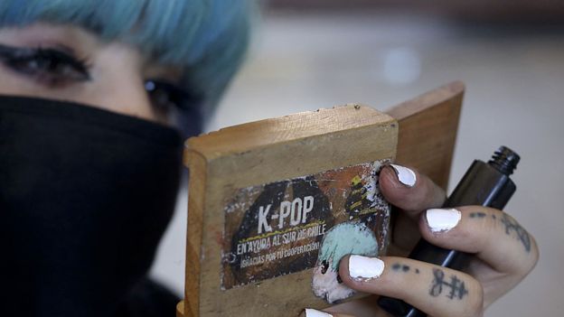Un miembro del grupo musical chileno 'Rough Bunnies', una banda de K-Pop que rinde homenaje a la banda surcoreana BAP, se maquilla antes de su presentación en Santiago, el 18 de marzo de 2018. La música coreana ha llegado a ser tan popular como el reggaetón o los artistas locales. (GETTY IMAGES).