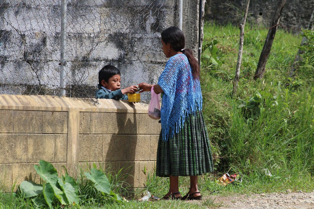Imelda Quib Batz alimenta a su hijo Henry Estuardo Quib a través del agujero de una malla, en Cobán, Alta Verapaz. (Foto Prensa Libre: Eduardo Sam)