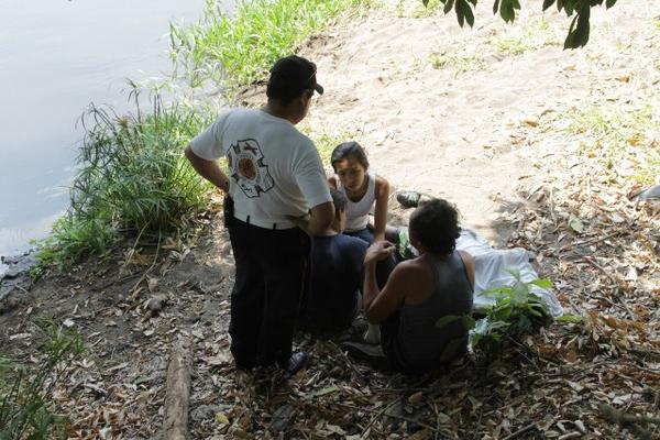 Familiares junto al cadáver de Estuardo Antonio Aguilar, quien murió ahogado en el río Michatoya en Escuintla. (Foto Prensa Libre: Enrique Paredes)