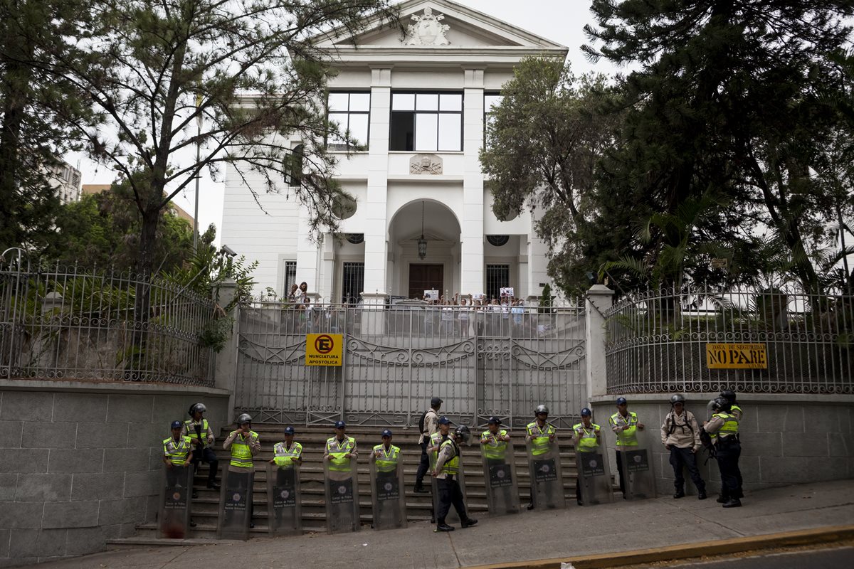 Agentes de la Policía venezolana custodian la sede de la Nunciatura Apostólica que fue tomada por familiares de los presos políticos. (Foto Prensa Libre: EFE).