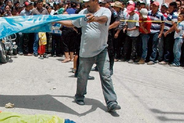 Curiosos observan el cadáver de  un hombre  ultimado en Sayaxché, Petén. (Foto Prensa Libre: Rigoberto Escobar)