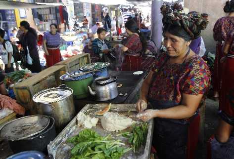 Una mujer  prepara alimentos en el mercado municipal de Nebaj. La calma  volvió al municipio después de las elecciones del domingo  último, que dieron como ganador a Pedro Raymundo.