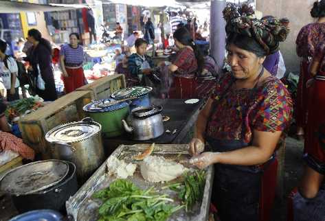 Una mujer  prepara alimentos en el mercado municipal de Nebaj. La calma  volvió al municipio después de las elecciones del domingo  último, que dieron como ganador a Pedro Raymundo.