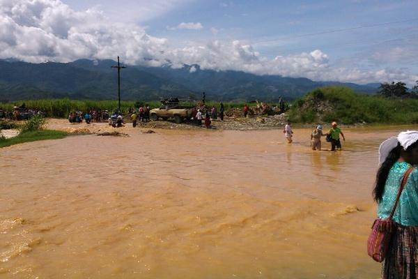 Pobladores tratan de atravesar el río Jocochiquín, en un sector de Panzós, el cual se halla crecido por la constante lluvia. (Foto Prensa Libre: Eduardo Sam Chun)