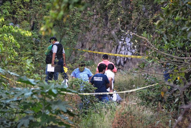Policías federales revisan el área donde encontraron cuerpos en Acapulco. (Foto Prensa Libre: EFE)