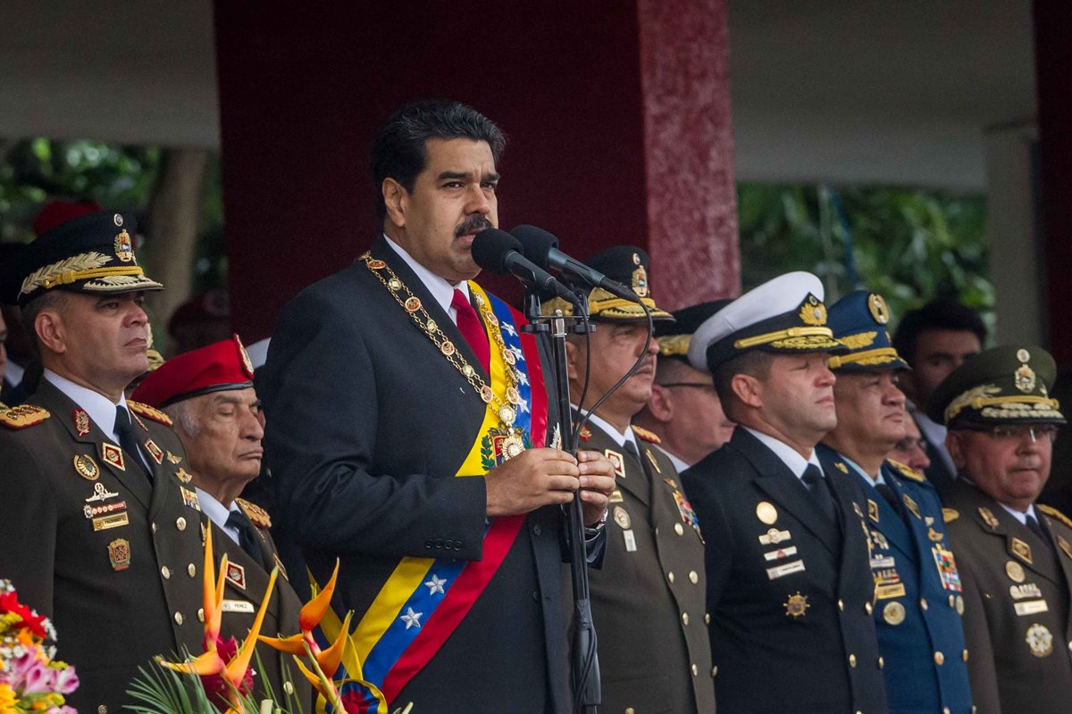 El presidente de Venezuela, Nicolás Maduro (al micrófono), comienza a cumplir su amenaza de tomar empresas. (Foto Prensa Libre: AFP).